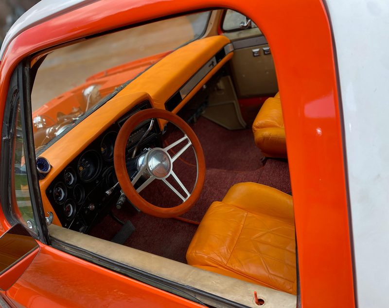 Interior con asientos de piel naranja, volante deportivo y relojes
